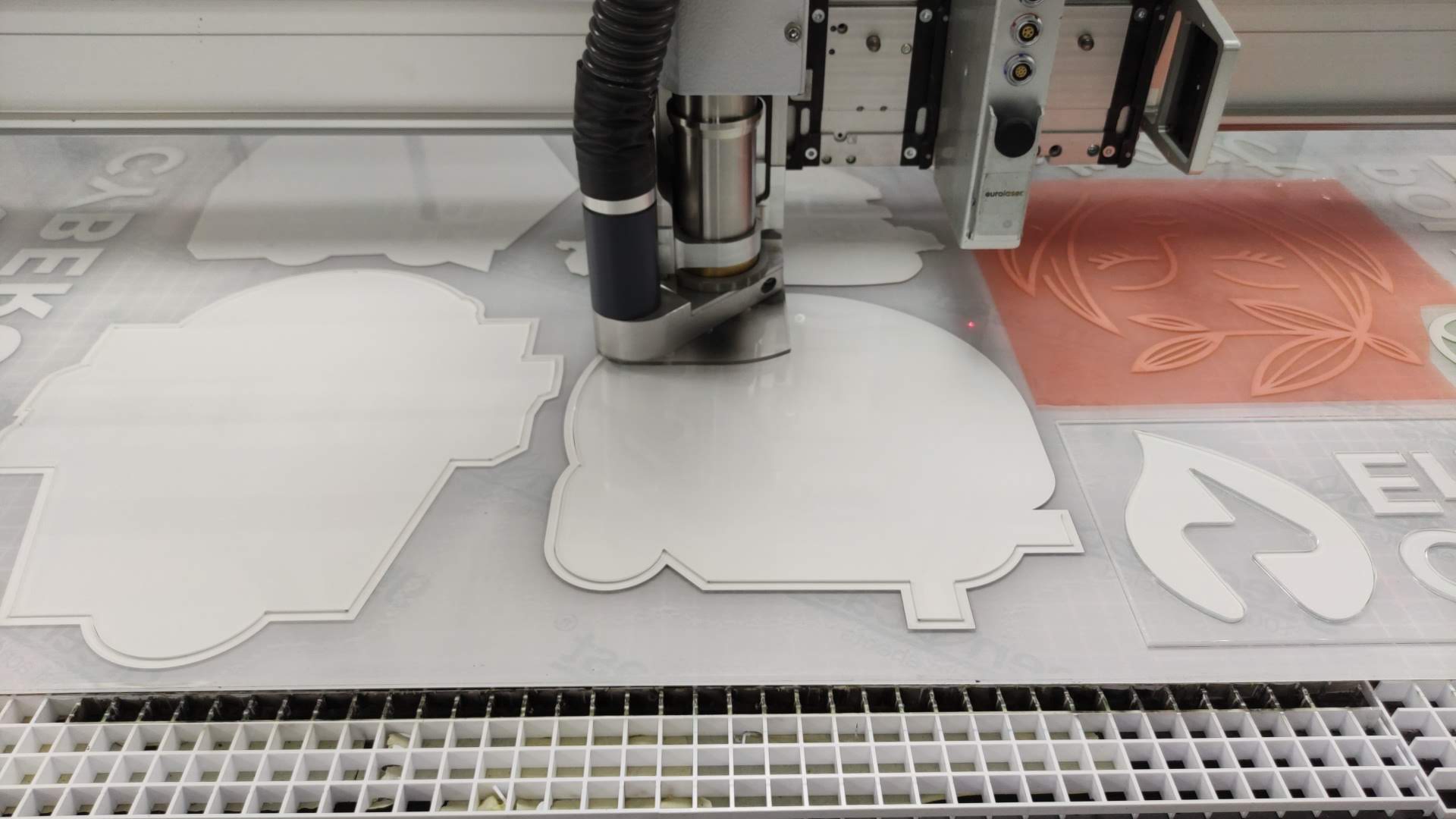 Acrylic sign shapes being cut on a CNC router in the Arcola workshop.
