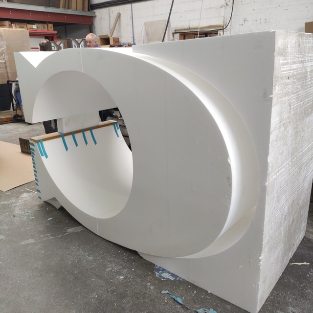 Large-scale CNC-cut foam letter in our fabrication workshop during production, showing precision curved cutouts and professional finishing process.