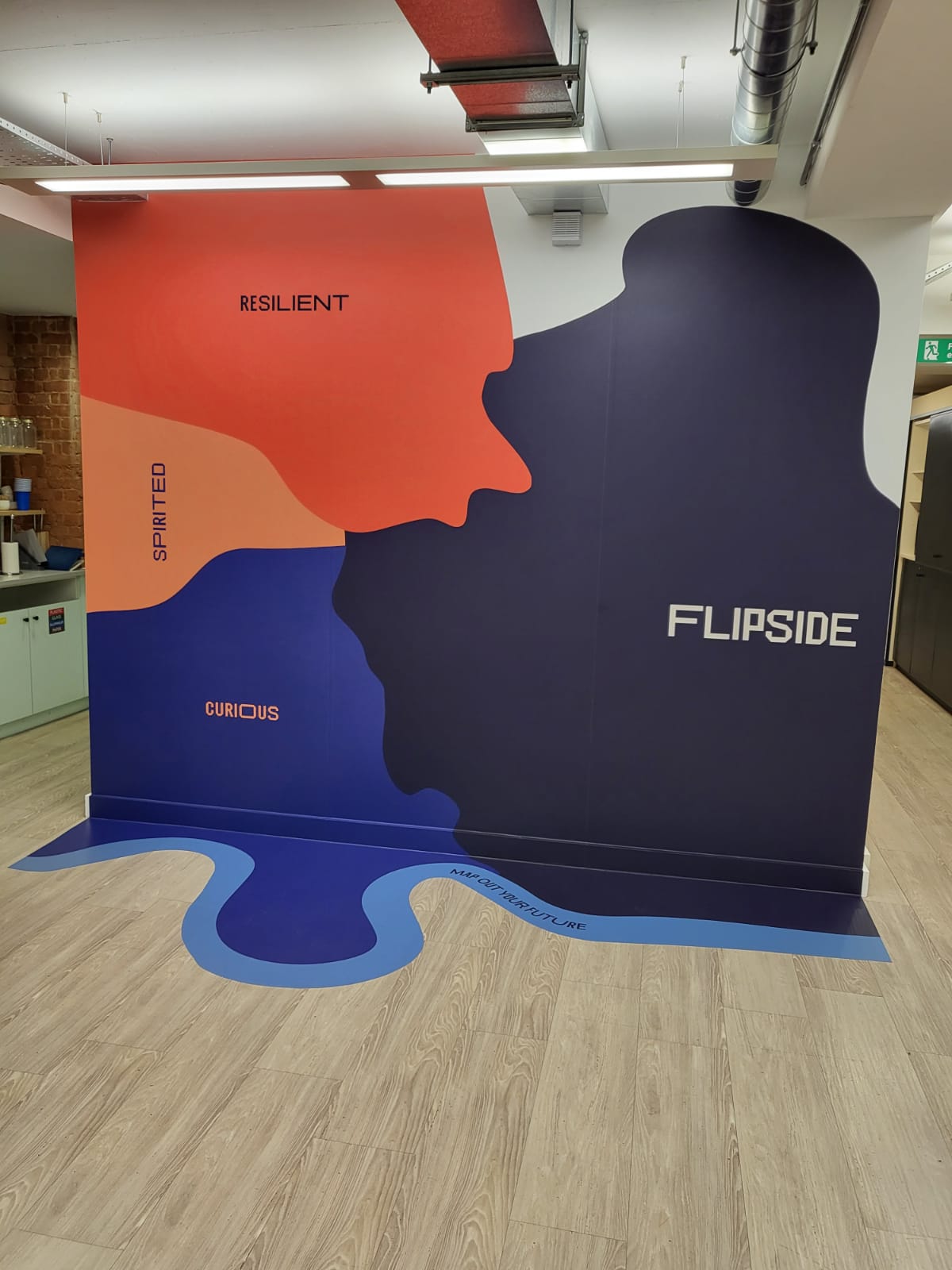 Installed large-format wall and floor vinyl mural in an office space featuring FLIPSIDE branding and abstract colour-block graphics.