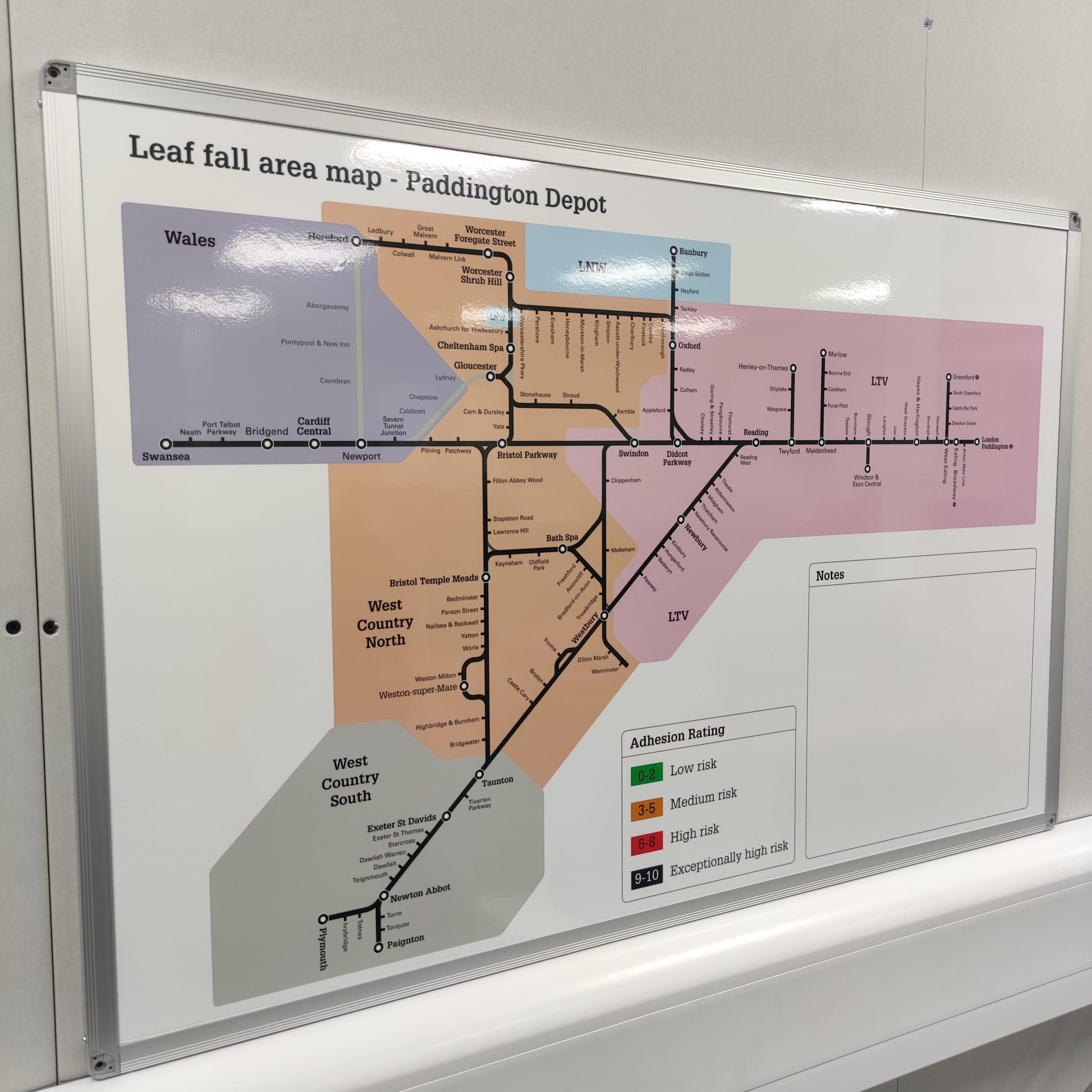 Framed large-format printed wayfinding map for Paddington Depot showing routes, zones and an adhesion rating legend, mounted on an internal wall.